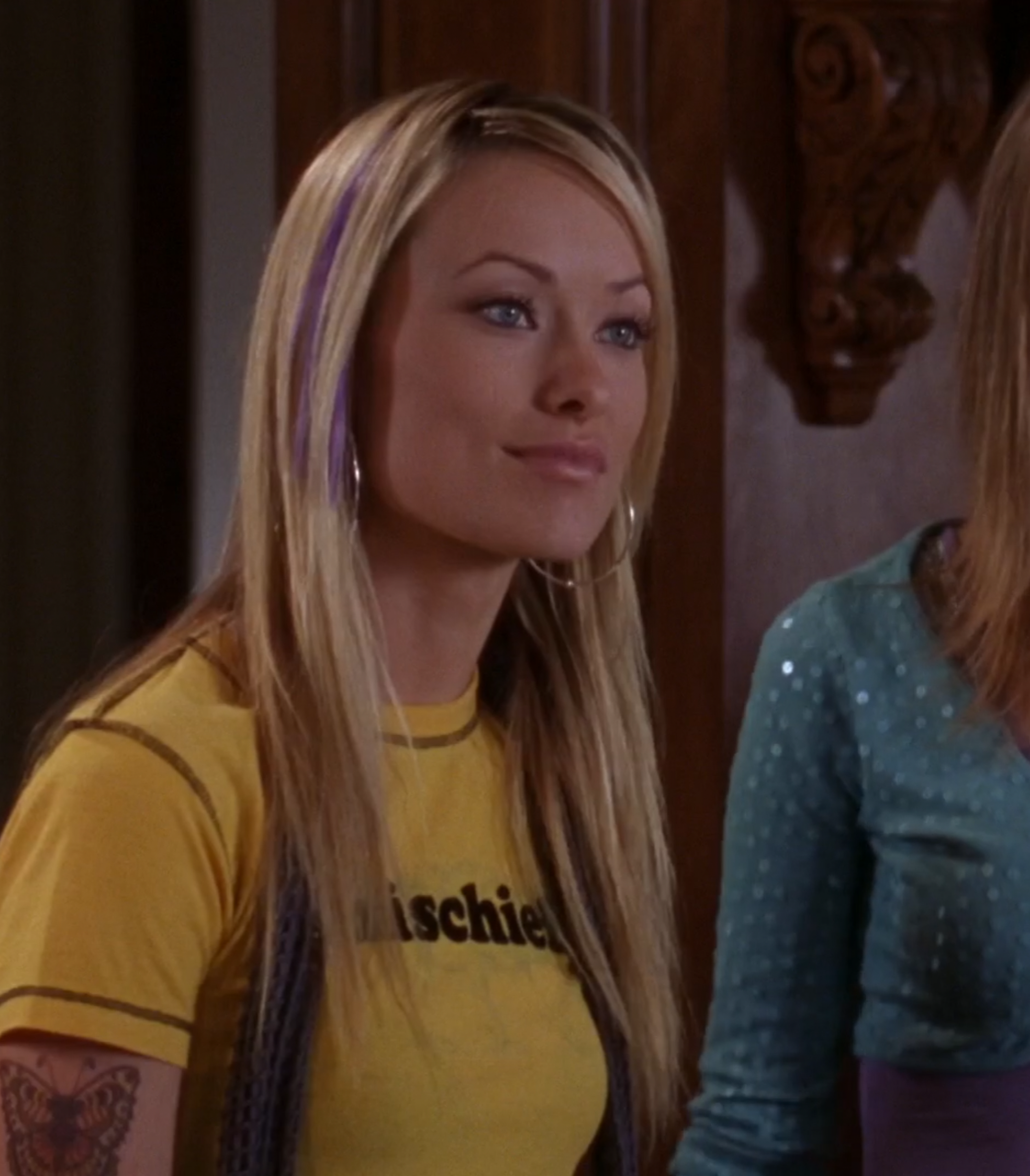 A screenshot from Season 2, Episode 14 of The O.C. of Alex and Marissa in the kitchen. Alex is wearing a yellow shirt with "Mischief" written across the chest.